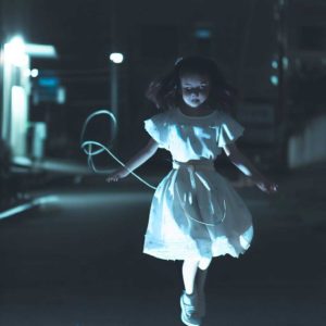 白いワンピースを着た縄跳びをする少女